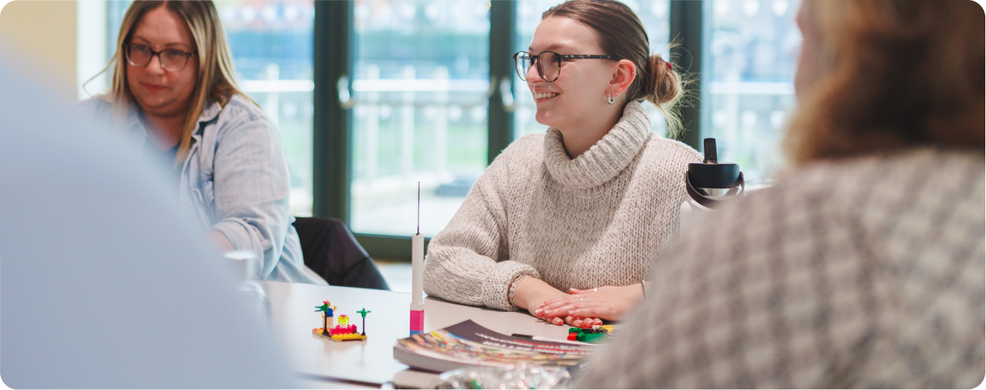 Woman smiling infront of legos